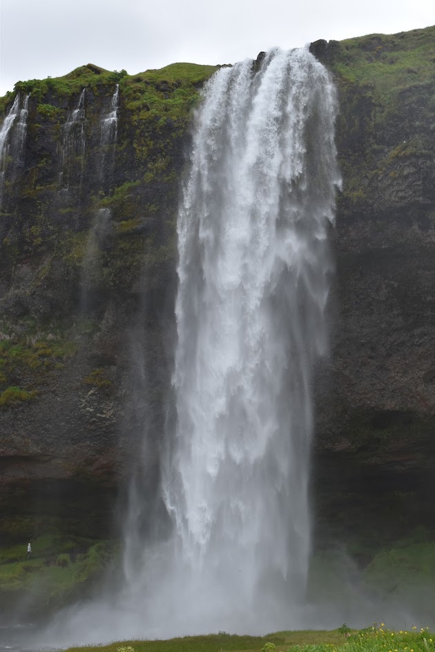 Seljalandsfoss is a 200 foot / 61 meter tall waterfall. The plunge waterfall can be explored and you can walk behind it. It was a cloudier day in this photo.