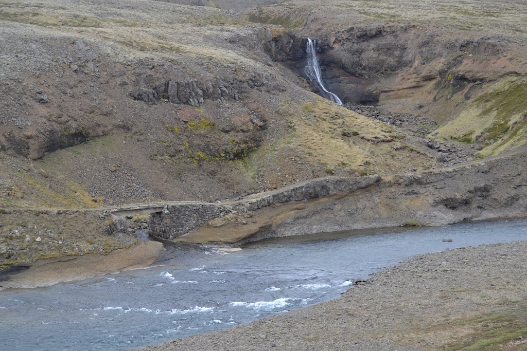 This is a waterfall near Kattarhryggur (Cat's Ridge). The main focus of this picture is the concrete bridge built to cross the stream in the 1930s. A road continues to along the river, and the waterfall is in the upper right corner.