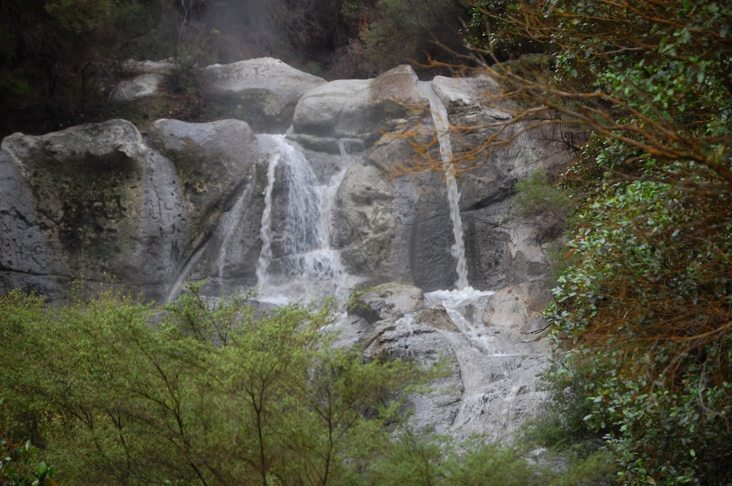 Kakahi Falls is a waterfall in New Zealand's Rotorua region. This drop is around 15 feet / 5 meters tall. The air looks misty around the falls because the water is rather warm and evaporates significantly.