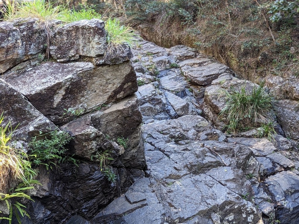 J. C. Slaughter Falls is a waterfall near Brisbane in Queensland, Australia. The height is approximately 30 feet or 10 meters tall, but it's difficult to tell how tall it is because very little water was flowing in May 2023.