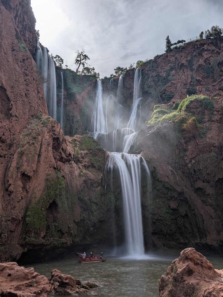 The Cascades D'Ouzoud (or Ouzoud Waterfall) is a 360 foot (110 meter) tall waterfall in the Atlas Mountains of Morocco. It is found in the town of Ouzoud. There are multiple drops to the waterfall, and in this photo, there is a boat near the base of the waterfall.